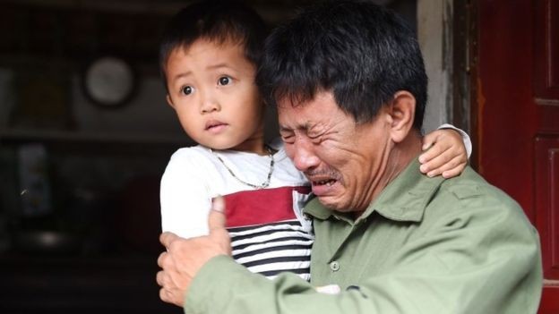 ông Lê Văn Tuấn ôm đứa cháu trai, bật khóc khi không có tin tức gì về người con trai Lê Văn Hà (ảnh: Getty Images) ông Lê Văn Tuấn ôm đứa cháu trai, bật khóc khi không có tin tức gì về người con trai Lê Văn Hà (ảnh: Getty Images)