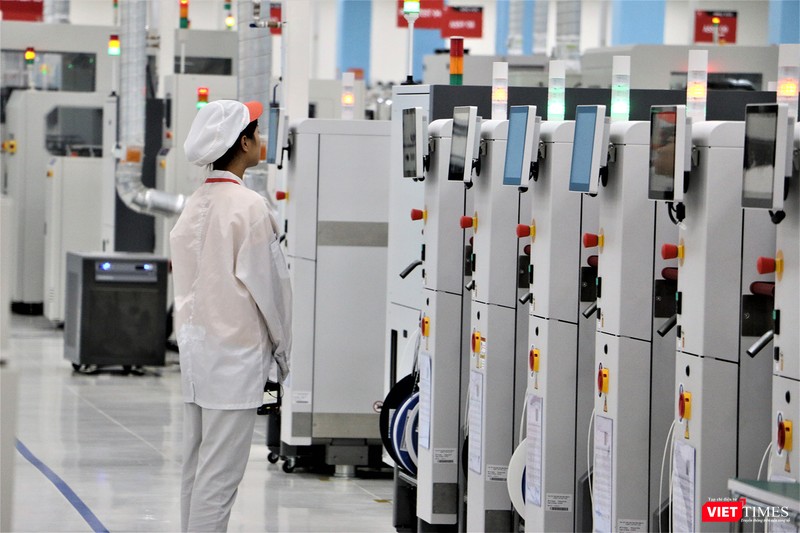 Một công nhân đang theo dõi quá trình sản xuất bảng mạch in