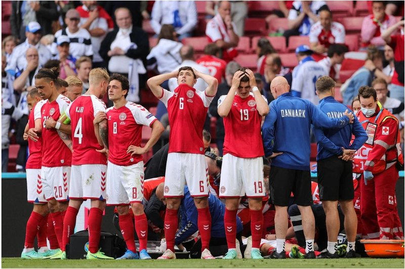 Sau khi Christian Eriksen bị đột quỵ và được cấp cứu trên sân, để bảo vệ quyền riêng tư cho anh, các cầu thủ Đan Mạch đã lập hàng rào che chắn. Ảnh: AFP.