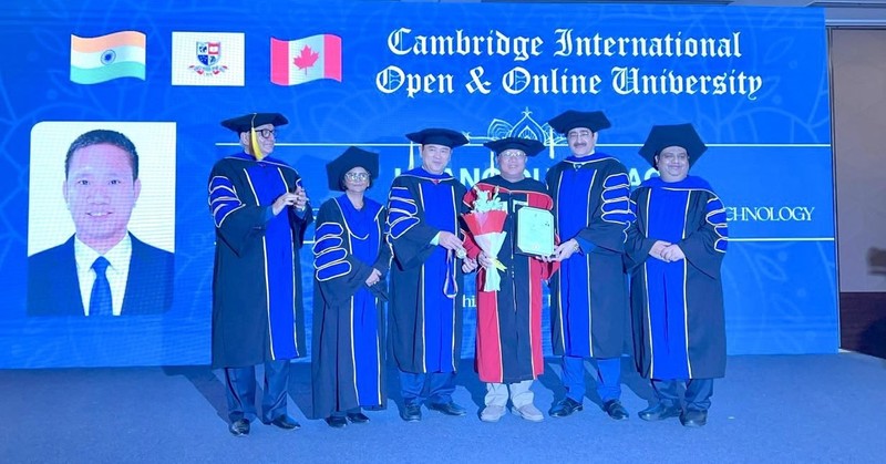 Ông Hoàng Đức Thảo (đứng giữa) nhận phong tặng của Trường Đại học Quốc tế mở - trực tuyến Cambridge. Hoang Duc Thao 2.jpg