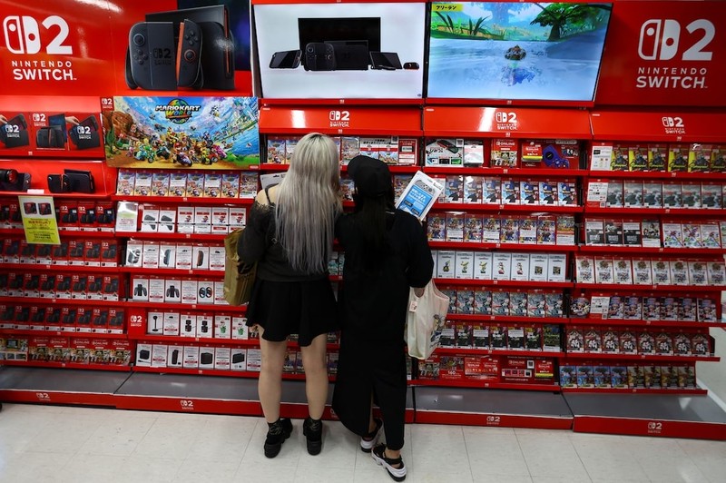 Khách hàng mua sắm tại một cửa hàng điện tử khi Nintendo bắt đầu bán máy chơi game mới trên toàn cầu. Ảnh: Reuters Nintendo Switch 2 - Reuters.jpg