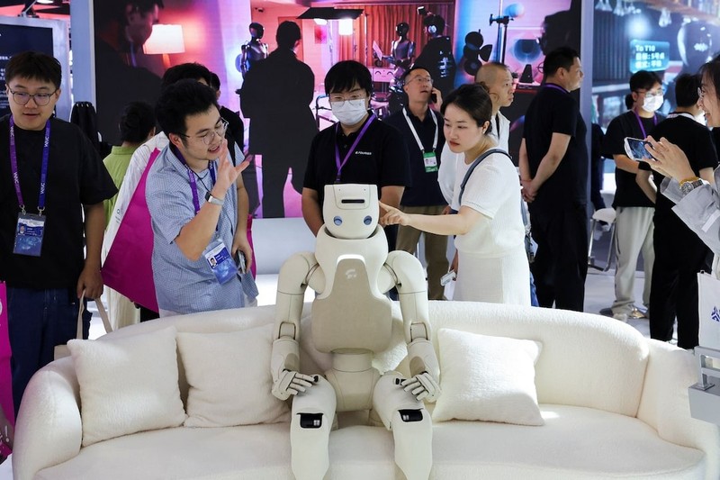 Khách tham quan tương tác với một robot hình người tại gian hàng Fourier trong Hội nghị AI thế giới ở Thượng Hải, Trung Quốc. Ảnh: Reuters Khach tham quan trien lam AI -Reuters.jpg