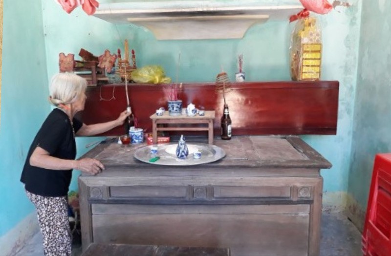 Cụ Phan Thị Nuôi thắp nén hương bên chiếc quan tài đã chuẩn bị sẵn cho mình, đặt ngay giữa căn nhà đơn sơ – hình ảnh ám ảnh về nỗi đau mất mát kéo dài sau chiến tranh. 2.jpg