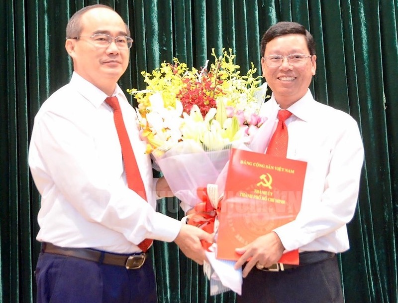 Bí thư Thành ủy TPHCM Nguyễn Thiện Nhân trao quyết định và hoa chúc mừng ông Vũ Ngọc Tuất.
