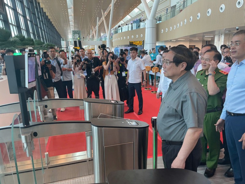 Thủ tướng Phạm Minh Chính trải nghiệm công nghệ xác thực khuôn mặt tại cửa ra máy bay bên trong nhà ga T3 sân bay Tân Sơn Nhất, sáng 19/4. Ảnh: Hà An. Thu tuong tham T3.jpg