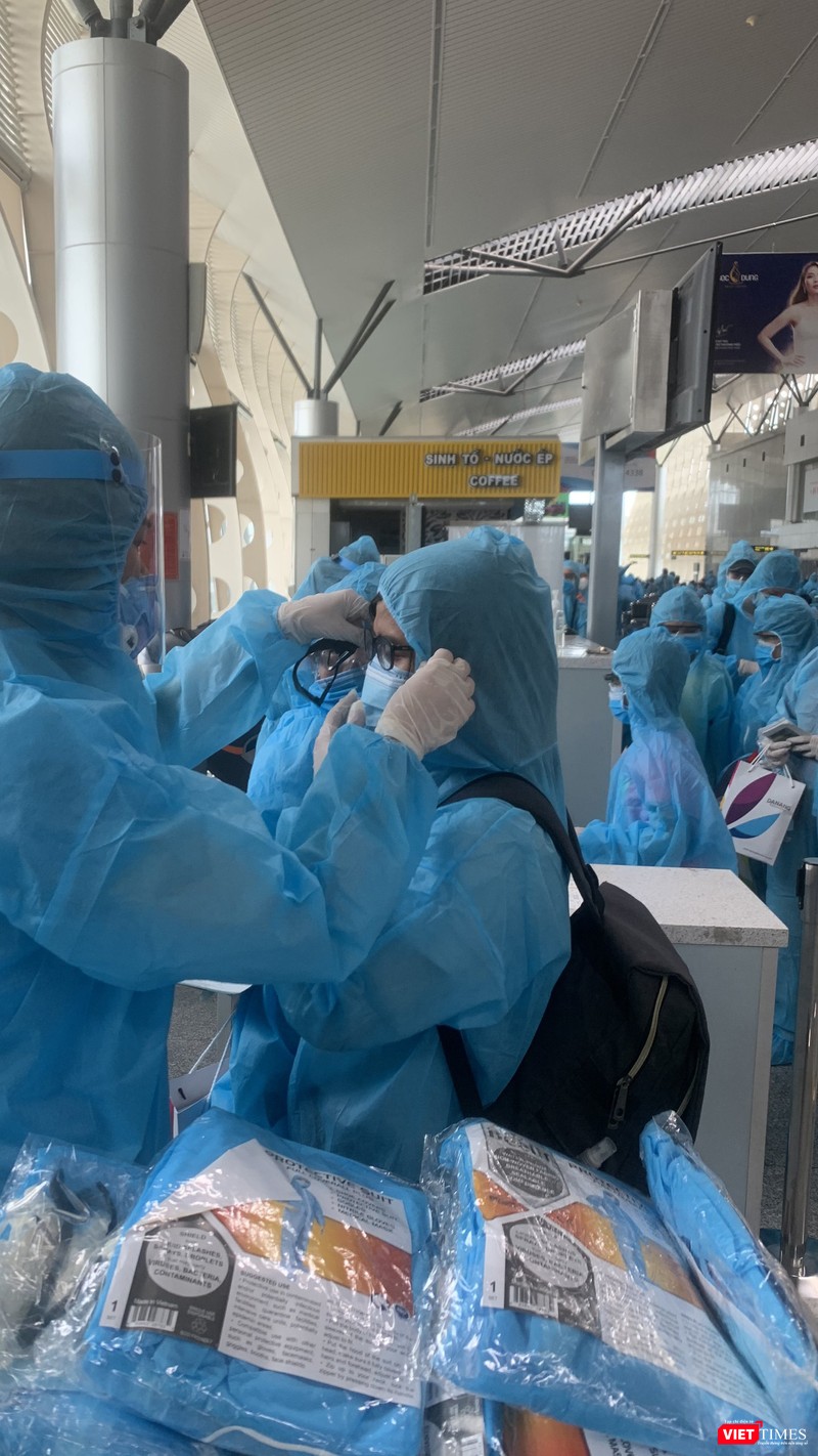 Thực hiện bảo hộ COVID-19 trước khi lên máy bay (Ảnh: VNA) 