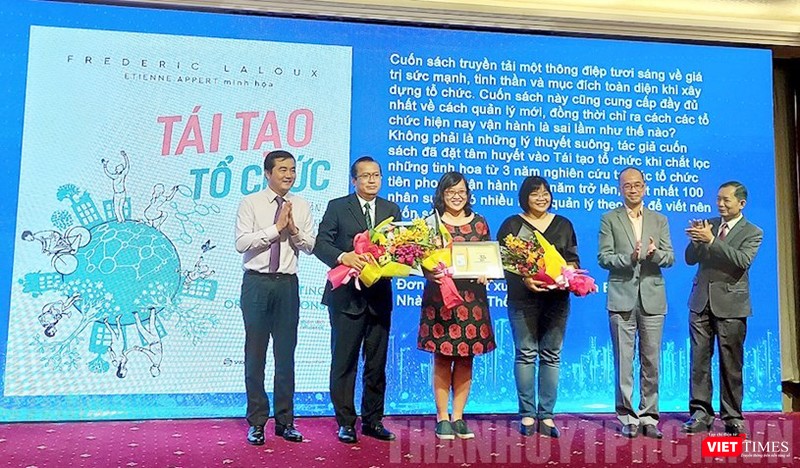 Giám đốc Sở Công thương TPHCM Bùi Tá Hoàng Vũ (trái) trao chứng nhận sách đáng đọc cho đơn vị xuất bản quyển “Tái tạo tổ chức”