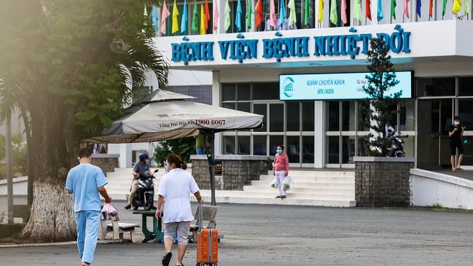 Nhân viên Bệnh viện Bệnh Nhiệt đới mang hành lý vào viện, sau khi bệnh viện phong tỏa. Ảnh- Hữu Khoa