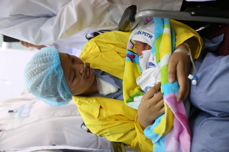 Chị Nguyễn Thị Liên ôm con trai là bé Đỗ Bình An trong lòng