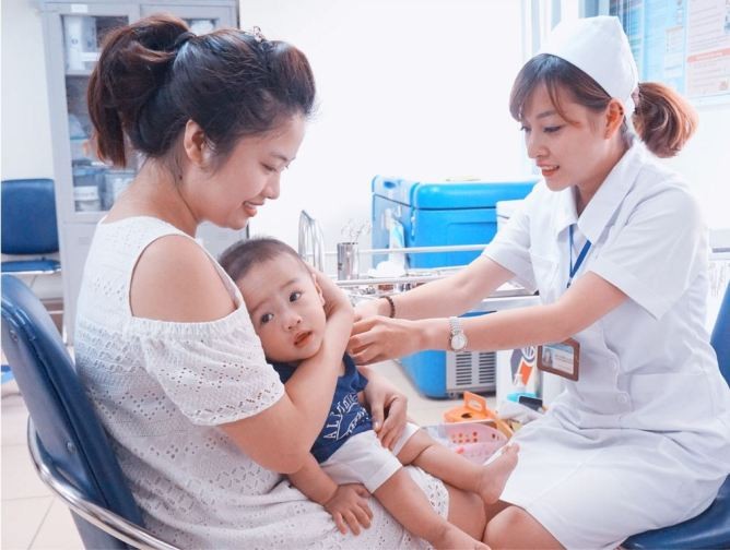Phụ huynh đưa trẻ đi tiêm vaccine.