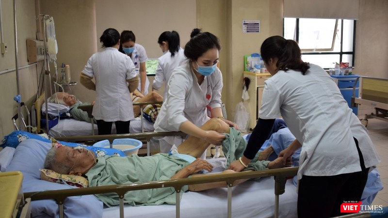 Một bệnh nhân nội trú mắc bệnh nặng được các điều dưỡng vệ sinh thân thể. Một bệnh nhân nội trú mắc bệnh nặng được các điều dưỡng vệ sinh thân thể.