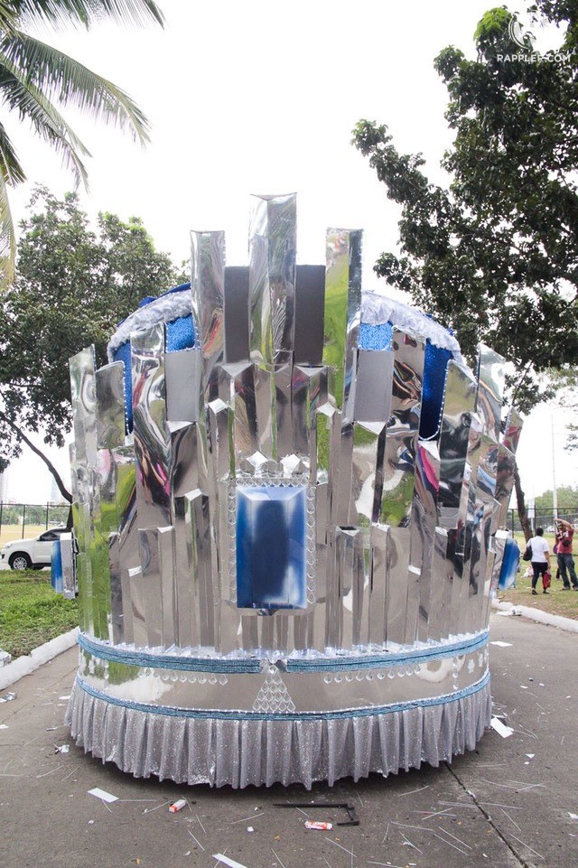 Chiếc xe diễu hành nhìn từ phía sau. Nó được thiết kế cách điệu từ hình ảnh vương miện đăng quang. Chiếc xe diễu hành nhìn từ phía sau. Nó được thiết kế cách điệu từ hình ảnh vương miện đăng quang.