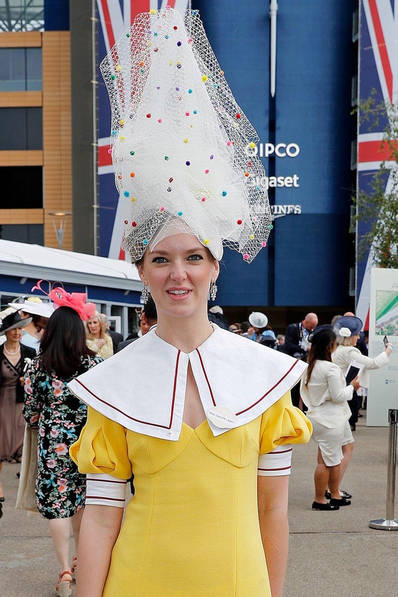 Charlotte Carroll đã đội một chiếc mũ bằng vải tuyn cao chọc trời với các dải trang trí nhiều màu trong suốt. Charlotte Carroll đã đội một chiếc mũ bằng vải tuyn cao chọc trời với các dải trang trí nhiều màu trong suốt.