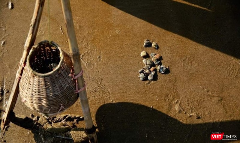 Dụng cụ cào ngao được làm bằng thanh tre, một giỏ tre treo lủng lẳng giữa thân