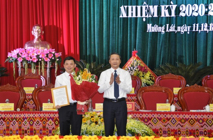 Ông Đỗ Minh Tuấn - Phó Bí thư Tỉnh ủy, trao quyết định và tặng hoa chúc mừng tân Bí thư Huyện ủy Mường Lát Hà Văn Ca. Ảnh: Quốc Hương