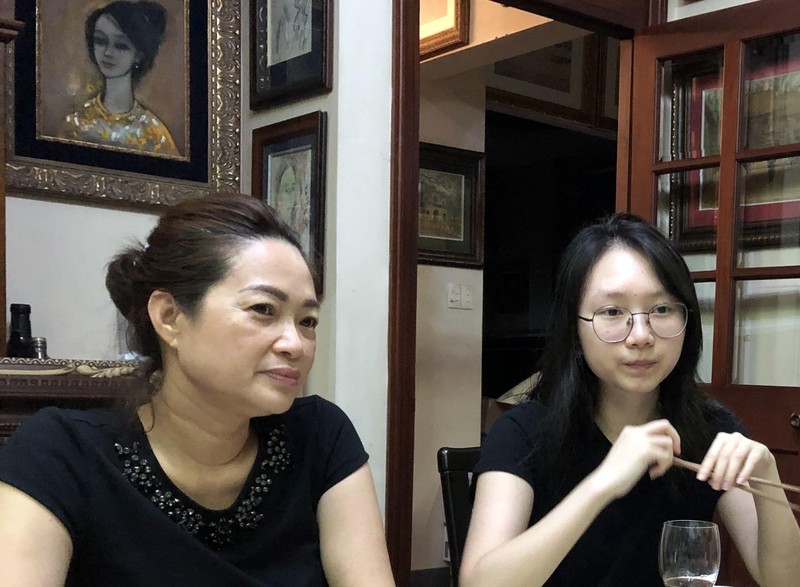 Minh Nguyệt vợ Quang Hói và cô con gái út đang bình luận về tranh trong bữa ăn. Ảnh Huỳnh Phan.