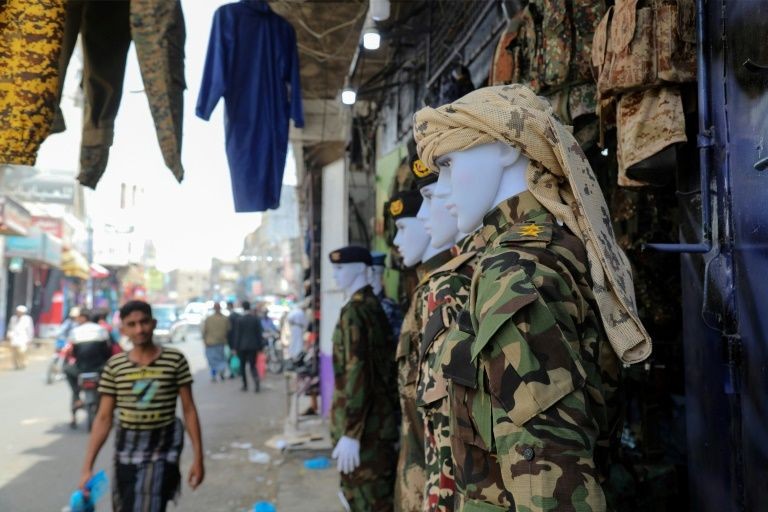 Các bộ áo lính treo bên ngoài một cửa hàng ở chợ truyền thống Taez (Ảnh: AFP) Các bộ áo lính treo bên ngoài một cửa hàng ở chợ truyền thống Taez (Ảnh: AFP)