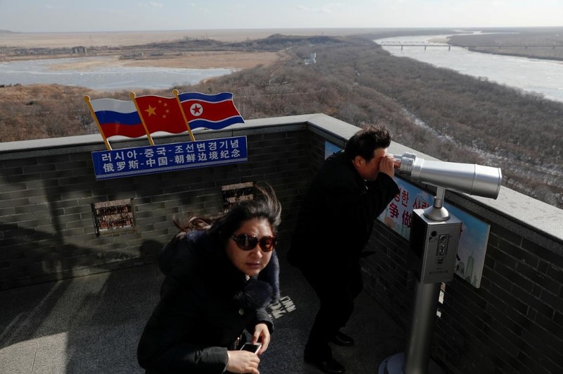 Một du khách Trung Quốc quan sát khu vực biên giới giữa Nga-Trung-Triều Tiên bằng ống nhòm (Ảnh: Reuters) Một du khách Trung Quốc quan sát khu vực biên giới giữa Nga-Trung-Triều Tiên bằng ống nhòm (Ảnh: Reuters)