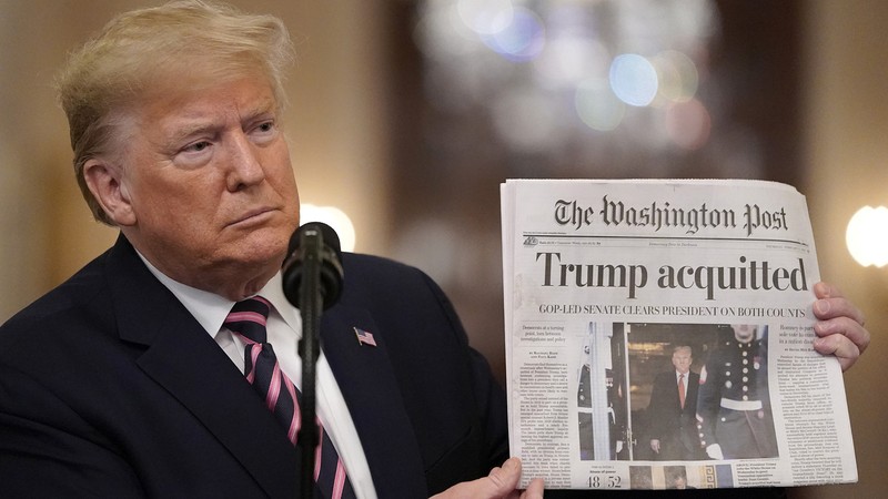 Ông Trump giơ cao trang bìa của tờ Washington Post có dòng tít lớn "Trump trắng án" trong cuộc họp báo tại Nhà Trắng, đồng thời "đá xoáy" ông Romney (Ảnh: Wall Street Journal) Ông Trump giơ cao trang bìa của tờ Washington Post có dòng tít lớn