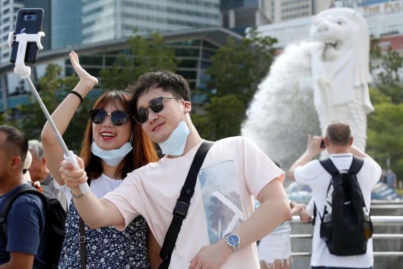 Du khách chụp ảnh tại công viên Merlion, Singapore (Ảnh: SCMP)