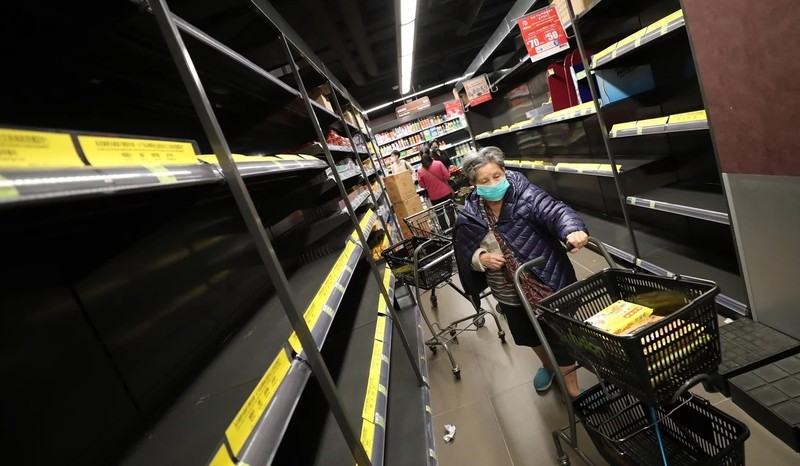 Một người phụ nữ đi dọc những kệ hàng trống không trong một siêu thị ở Hong Kong (Ảnh: SCMP)