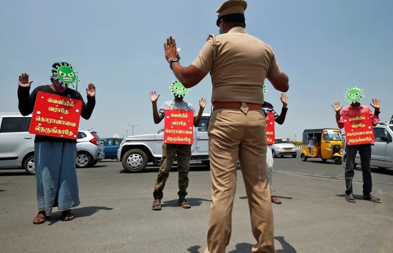 Một số tài xế bị xử phạt bằng cách đeo mặt nạ virus corona cùng tấm bảng có ghi "Đừng ra ngoài, Đừng đến gần corona" (Ảnh: Reuters) Một số tài xế bị xử phạt bằng cách đeo mặt nạ virus corona cùng tấm bảng có ghi