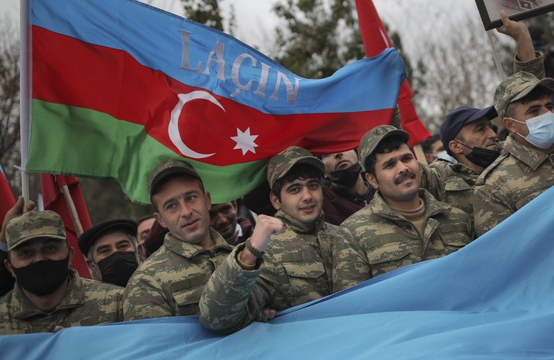 Binh sĩ Azerbaijan giơ cao lá quốc kỳ bên trên có dòng chữ "Lachin" để ăn mừng chiến thắng (Ảnh: AP)