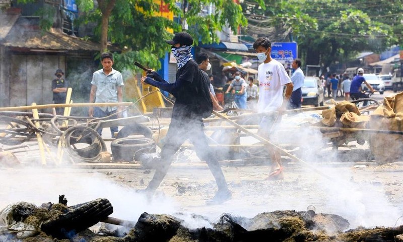 Người biểu tình đi giữa các chướng ngại vật ở thành phố Yangon hôm 27/3. Ảnh: AFP.