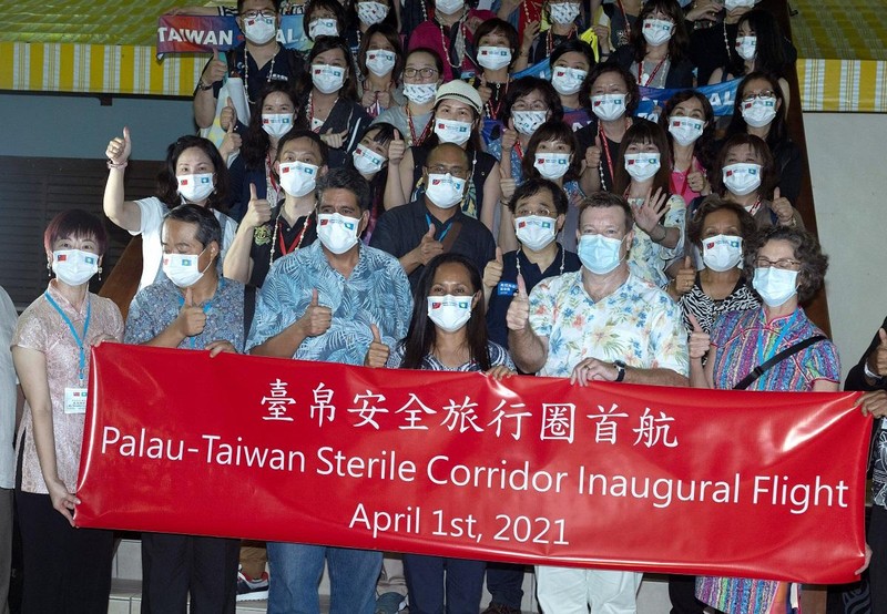 Tổng thống Palau Surangel Whipps (thứ 3 từ trái sang) chụp ảnh cùng du khách Đài Loan tới Palau vào ngày 1/4/2021 (Ảnh: AFP)