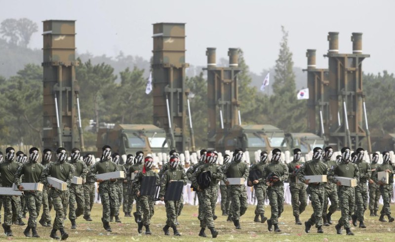 Binh sĩ Hàn Quốc thể hiện kỹ năng chiến đấu, đằng sau là hệ thống Hyunmoo-2 và Hyunmoo-3 (Ảnh: AP)