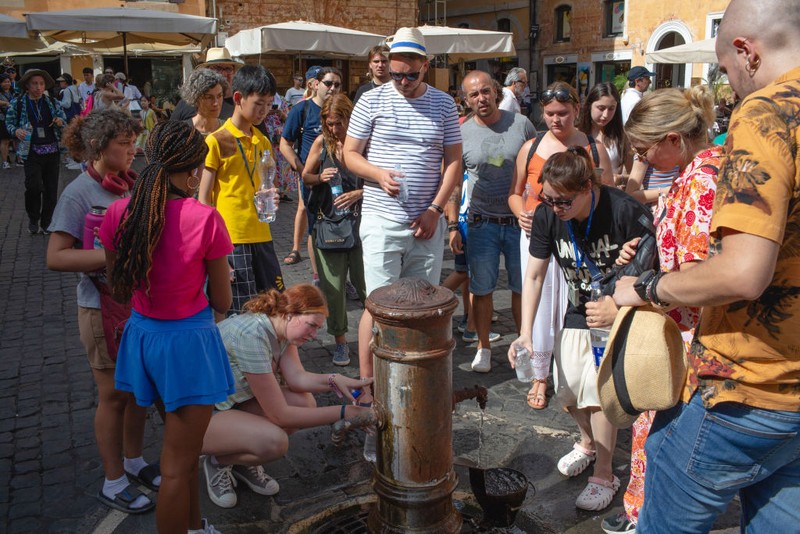 Du khách ở Rome bao quanh một vòi nước công cộng giữa tiết trời nắng nóng (Ảnh: Bloomberg) 4.jpg