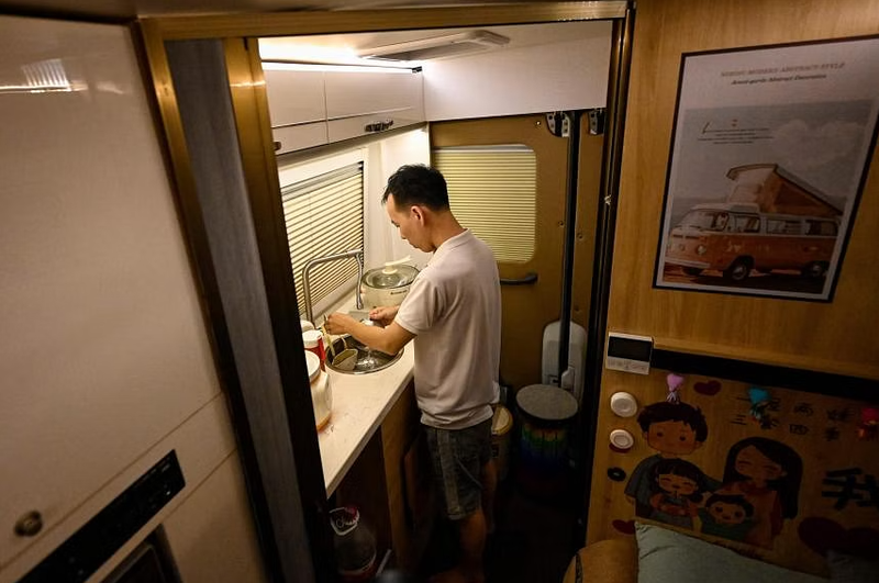 Li rửa bát bên trong chiếc xe van của mình ở Thâm Quyến (Ảnh: AFP) 2.png