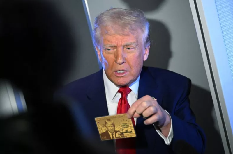 Tổng thống Mỹ Donald Trump cầm Thẻ vàng trị giá 5 triệu USD khi phát biểu với các phóng viên trên chuyên cơ Không lực Một, trên đường đến Miami vào ngày 3/4. Ảnh: AFP.