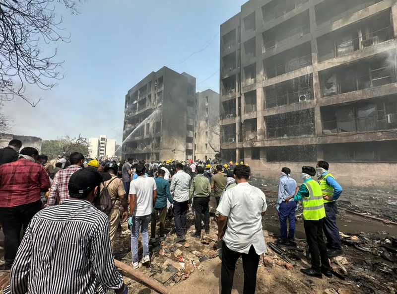 Mọi người tụ tập gần địa điểm máy bay Air India bị rơi ở Ahmedabad, Ấn Độ. Ảnh: Reuters. Roi may bay An Do 7.png