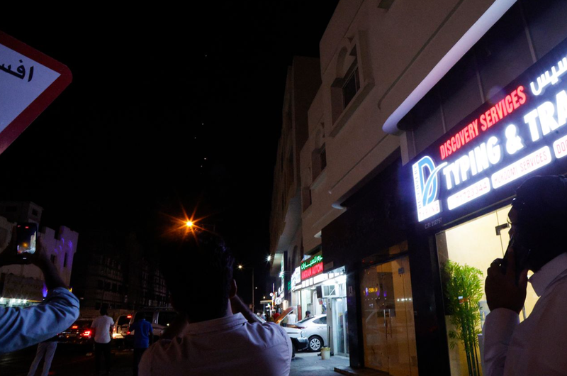 Người dân quay phim về các vật thể bay qua Doha ở Qatar trong hôm 23/6. Ảnh: AFP. Iran tan cong can cu My o Qatar 3.png