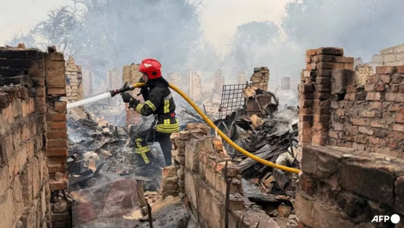 Bức ảnh do Cơ quan Tình trạng Khẩn cấp Nhà nước Ukraine chụp và công bố vào ngày 9/7 cho thấy cảnh một lính cứu hỏa đang dập tắt đám cháy sau một cuộc tấn công của Nga ở khu vực Zhytomyr. Ảnh: AFP. Nga nắn gân đối thủ bằng 728 UAV Ukraine cầu viện khẩn cấp, NATO vào thế sẵn sàng.png