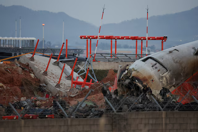 Xác của máy bay Jeju Air tại Sân bay quốc tế Muan, nằm gần một công trình bê tông nơi nó đâm vào, ngày 30/12/2024. Ảnh: Reuters.