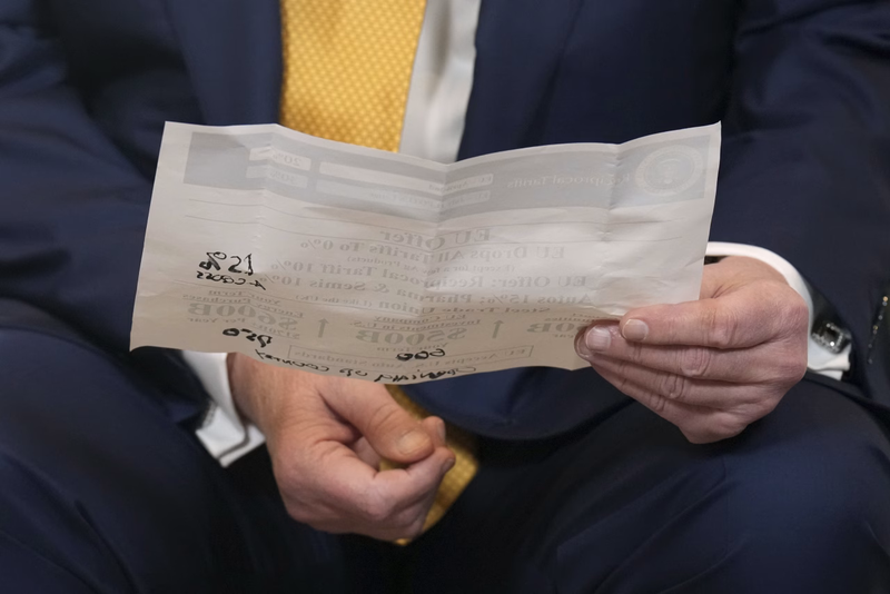 Tổng thống Trump cầm một tờ giấy sau khi đạt được thỏa thuận thương mại với các nhà đàm phán châu Âu. Ảnh: WSJ. Ông Trump giành thế thượng phong trước EU trong đàm phán thuế quan như thế nào 2.png