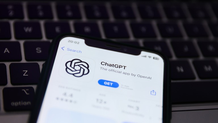 Bàn phím máy tính xách tay và trang web ChatGPT hiển thị trên màn hình điện thoại. Ảnh: Getty.