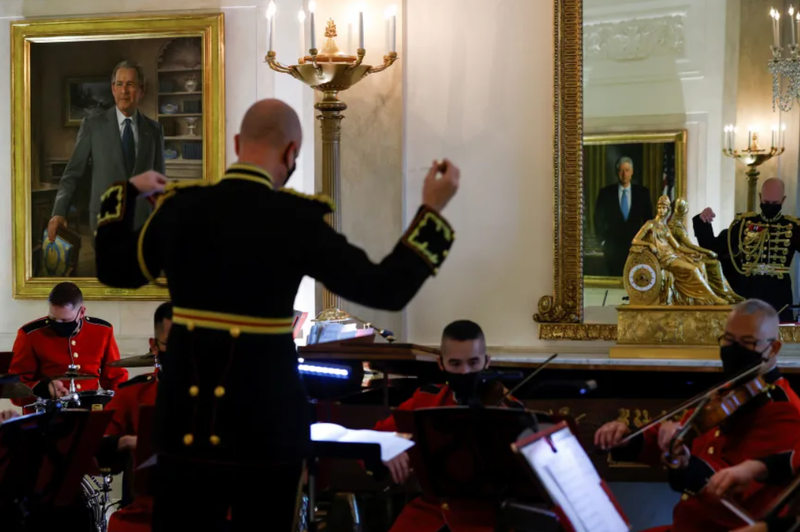 Ảnh chân dung của cựu Tổng thống George W. Bush được nhìn thấy ở bên trái, khi các thành viên của Ban nhạc Thủy quân Lục chiến Mỹ chơi nhạc lễ trong chuyến tham quan về đồ trang trí Giáng sinh của Nhà Trắng vào tháng 11/2021. Ảnh: Reuters. Ông Trump di dời chân dung ông Obama và gia tộc Bush vào góc kín của Nhà Trắng 2.png