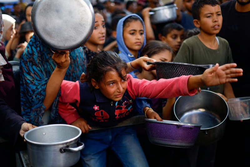 Người dân Palestine tập trung để nhận thực phẩm từ một bếp ăn từ thiện ở Nuseirat, trung tâm Dải Gaza. Ảnh: Reuters. Ông Trump, ông Netanyahu và ván bài cuối ở Trung Đông Liệu Gaza có thể im tiếng súng 7.png