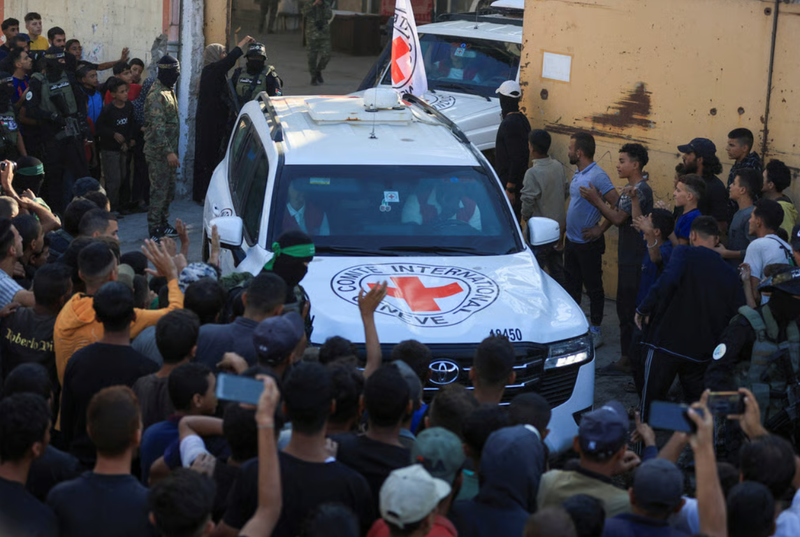Xe của Hội Chữ thập đỏ vận chuyển con tin sau khi bàn giao tại Thành phố Gaza. Ảnh: Reuters. Gaza bừng hy vọng Hamas trao trả con tin, ông Trump tuyên bố chiến tranh kết thúc 2.png