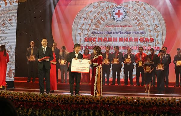 Phó tổng giám đốc Tổng công ty VTC Dương Thế Lương đại diện Cổng 1400 trao biển biểu trưng hơn 2,3 tỉ đồng cho bà Nguyễn Thị Xuân Thu-Chủ tịch Hội Chữ thập đỏ Việt Nam tối 7/1/2018, tại Hà Nội.