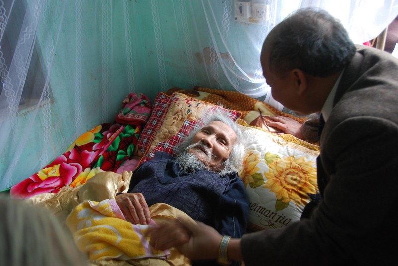 Bộ trưởng Nguyễn Quốc Triệu đọc bài thơ "Màu tím Hoa sim" cho Hữu Loan nghe. Ảnh: Xuân Ba. Bộ trưởng Nguyễn Quôc Triệu đọc bài thơ