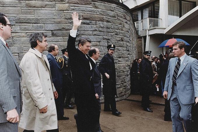 Ronald Reagan vẫy tay chào người dân và báo chí khi rời khỏi khách sạn Hilton tại Washington và bị ám sát hút chết ngày 3031981. Ảnh Corbis.