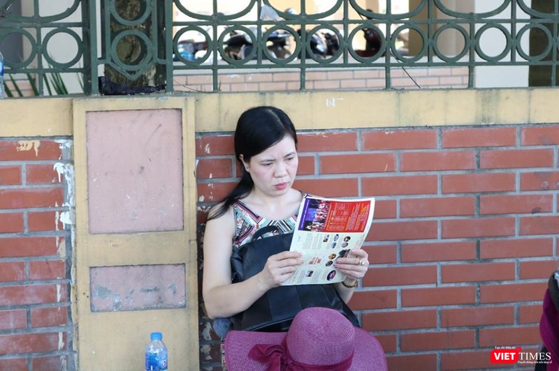 Một phụ huynh tranh thủ tìm hiểu thông tin tuyển sinh. Ảnh: Minh Thúy