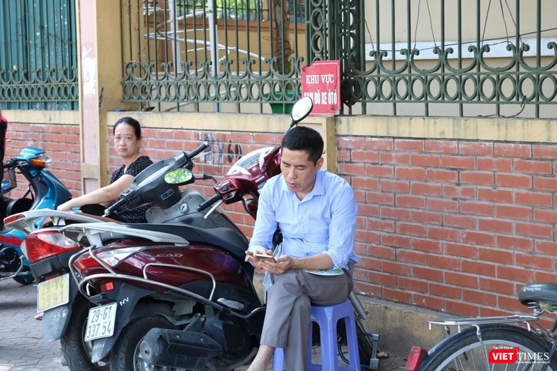 Phụ huynh chờ đợi con thi, sự mệt mỏi, lo lắng thể hiện rõ trên nét mặt. Ảnh: Minh Thúy