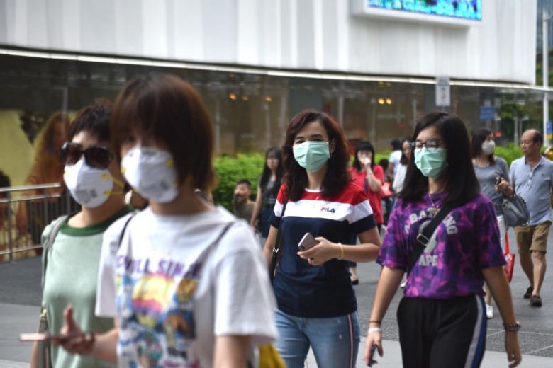 Người dân đeo khẩu trang khi xuống đường. Ảnh: KELLY HUI