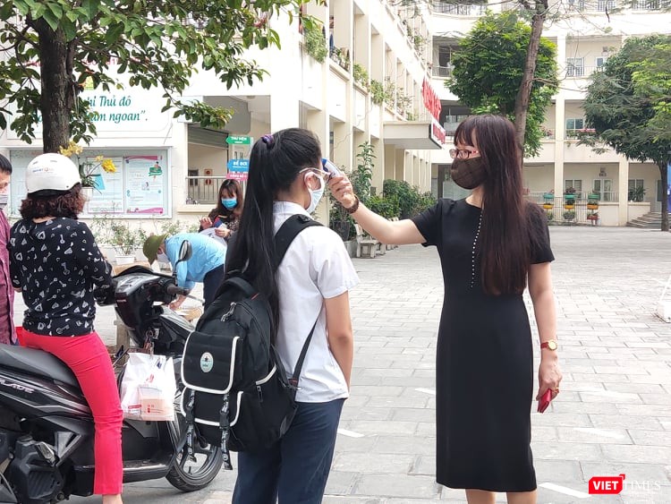 Học sinh được đo thân nhiệt trước khi đến lớp. Ảnh: Minh Thúy Học sinh được đo thân nhiệt trước khi đến lớp. Ảnh: Minh Thúy