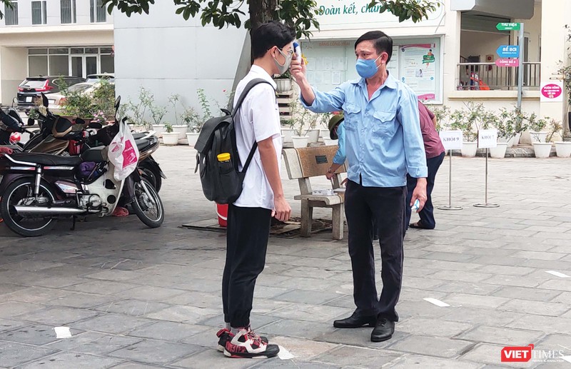 Học sinh được đo nhiệt độ trước khi vào lớp. Ảnh: Minh Thúy
